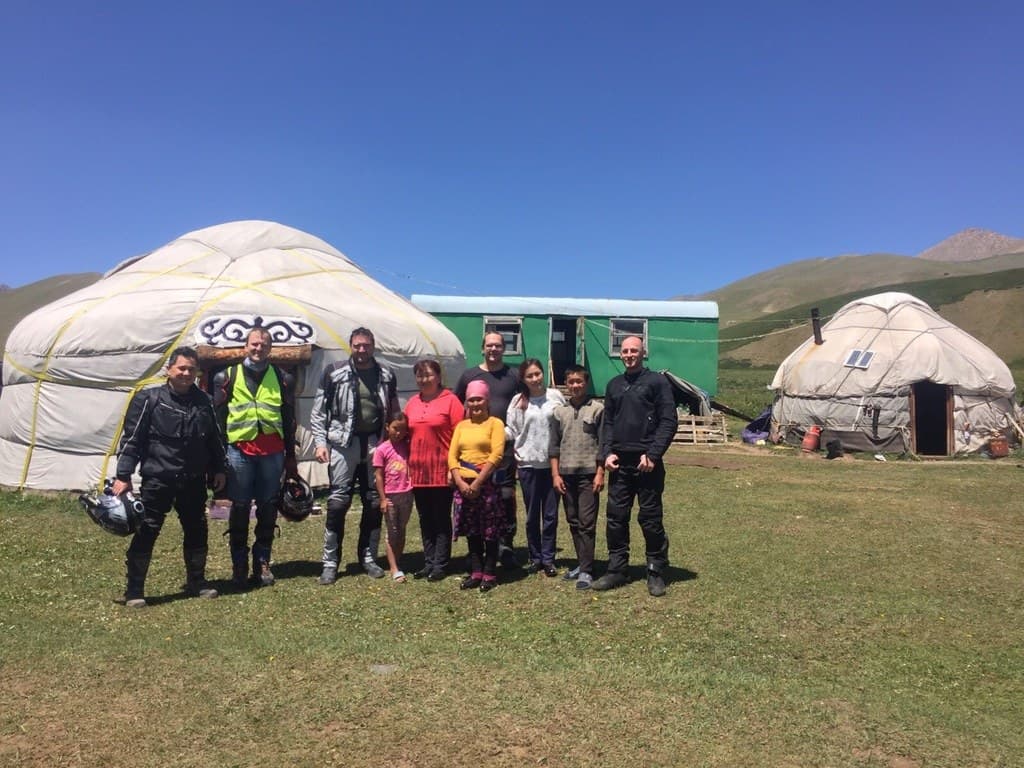 Group photo with yurts in the mountains